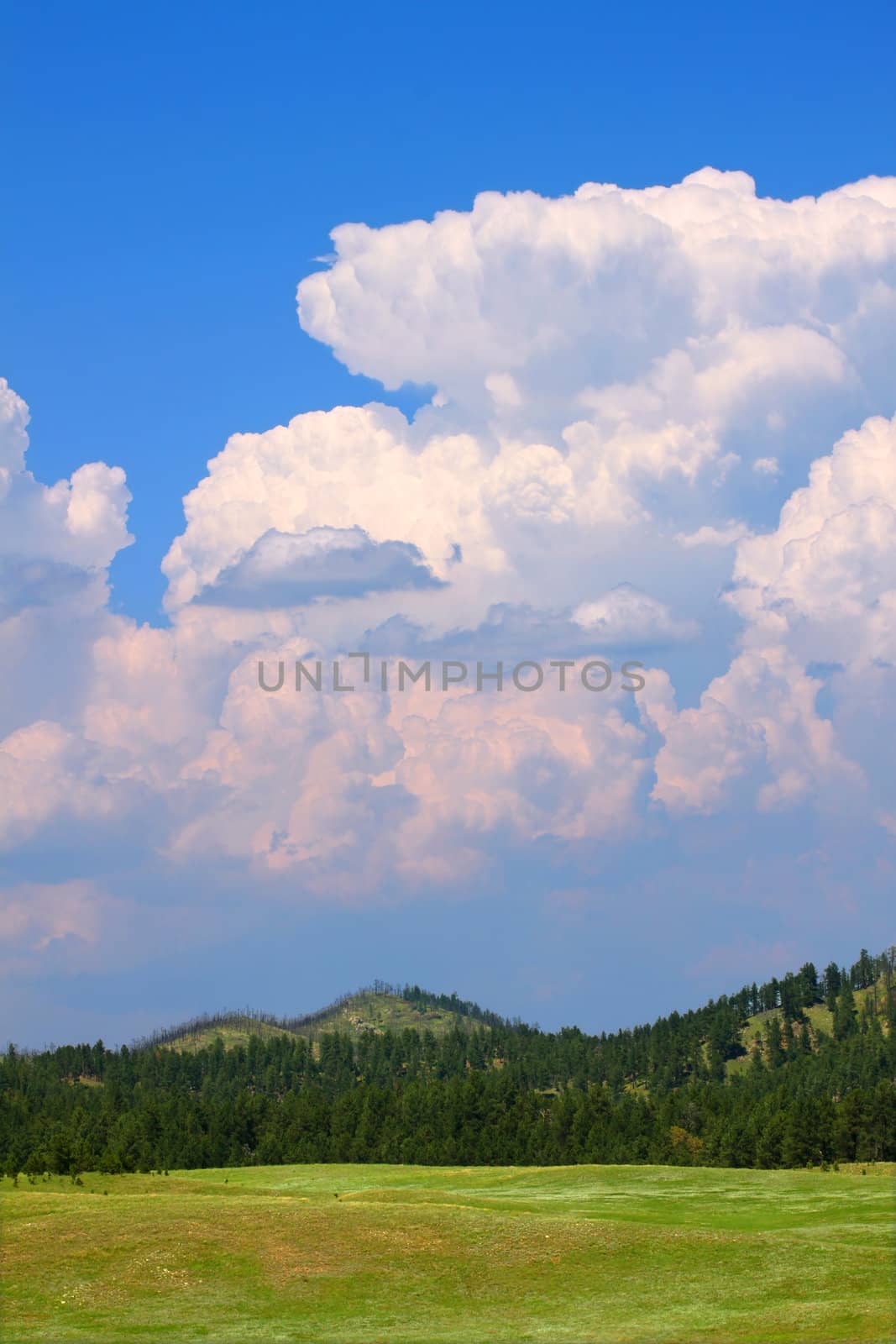 Giant cumulonimbus storm clouds erupt over the landscape of western South Dakota.