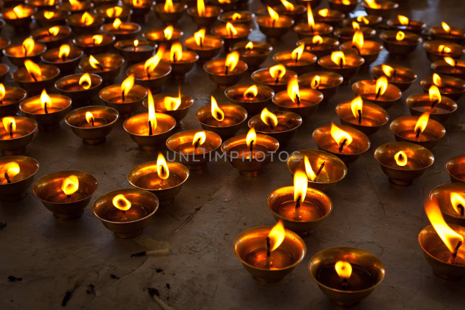 Burning candles in Buddhist temple. McLeod Ganj, Himachal Prades by dimol