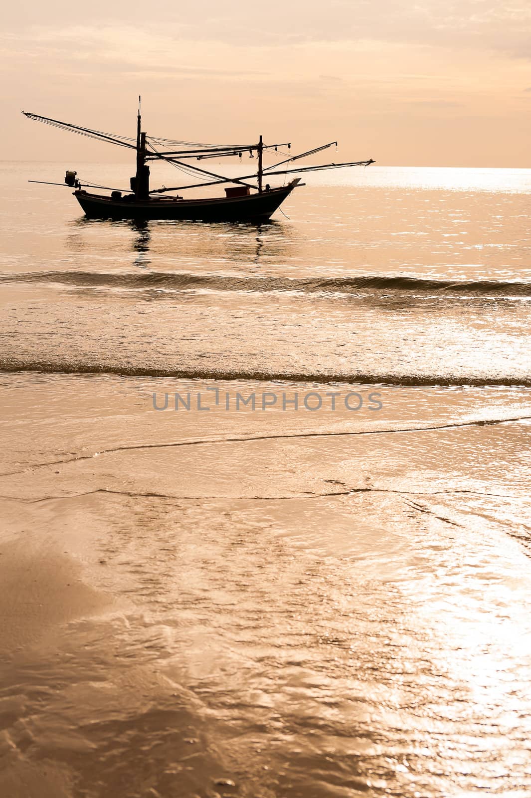 Green fishing boat thai silhouette on the sea in sunset time