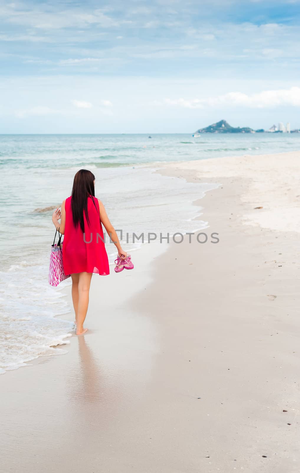 Woman red shirt walking on the beach