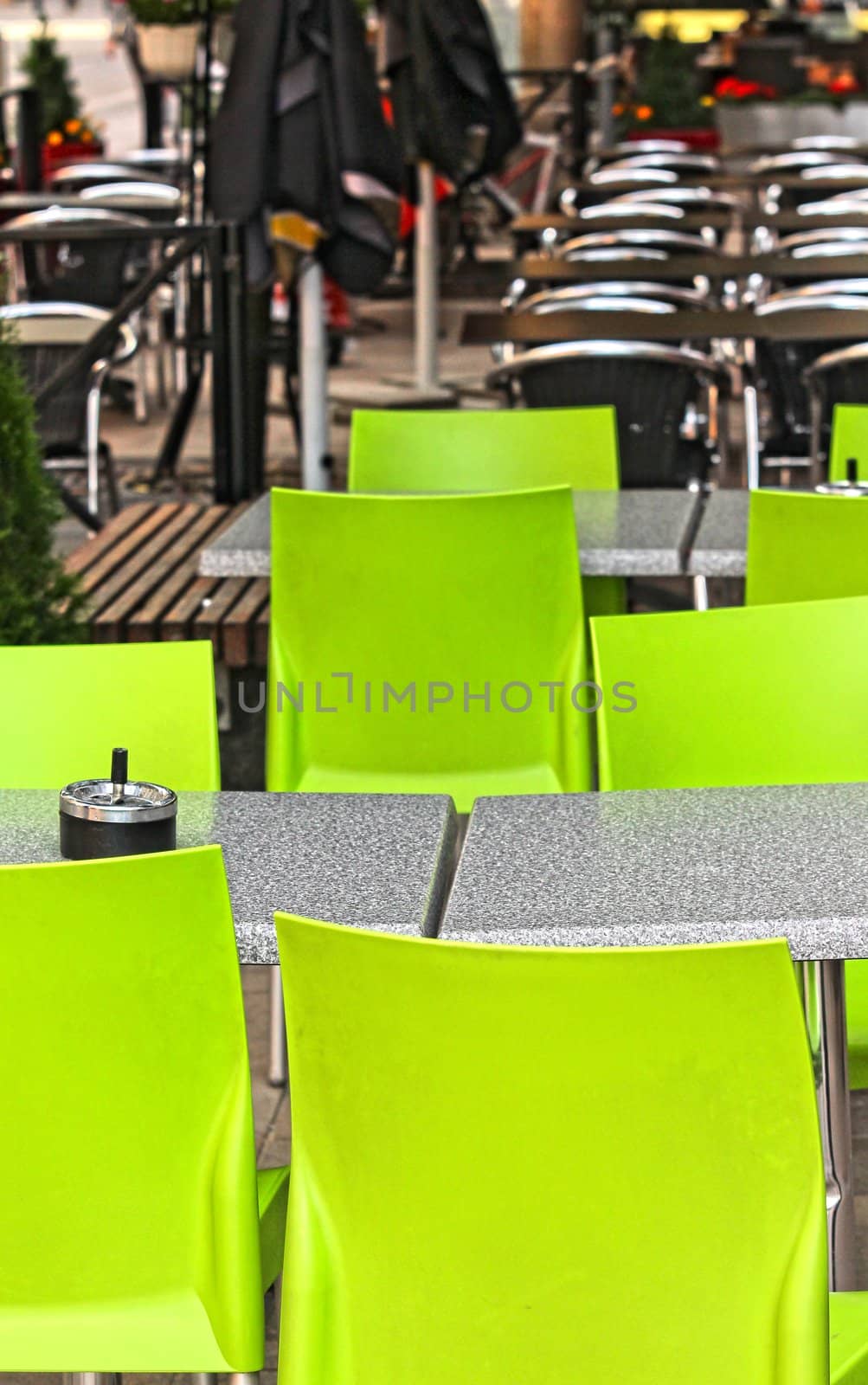 Restaurant outdoors with green chairs, nobody around