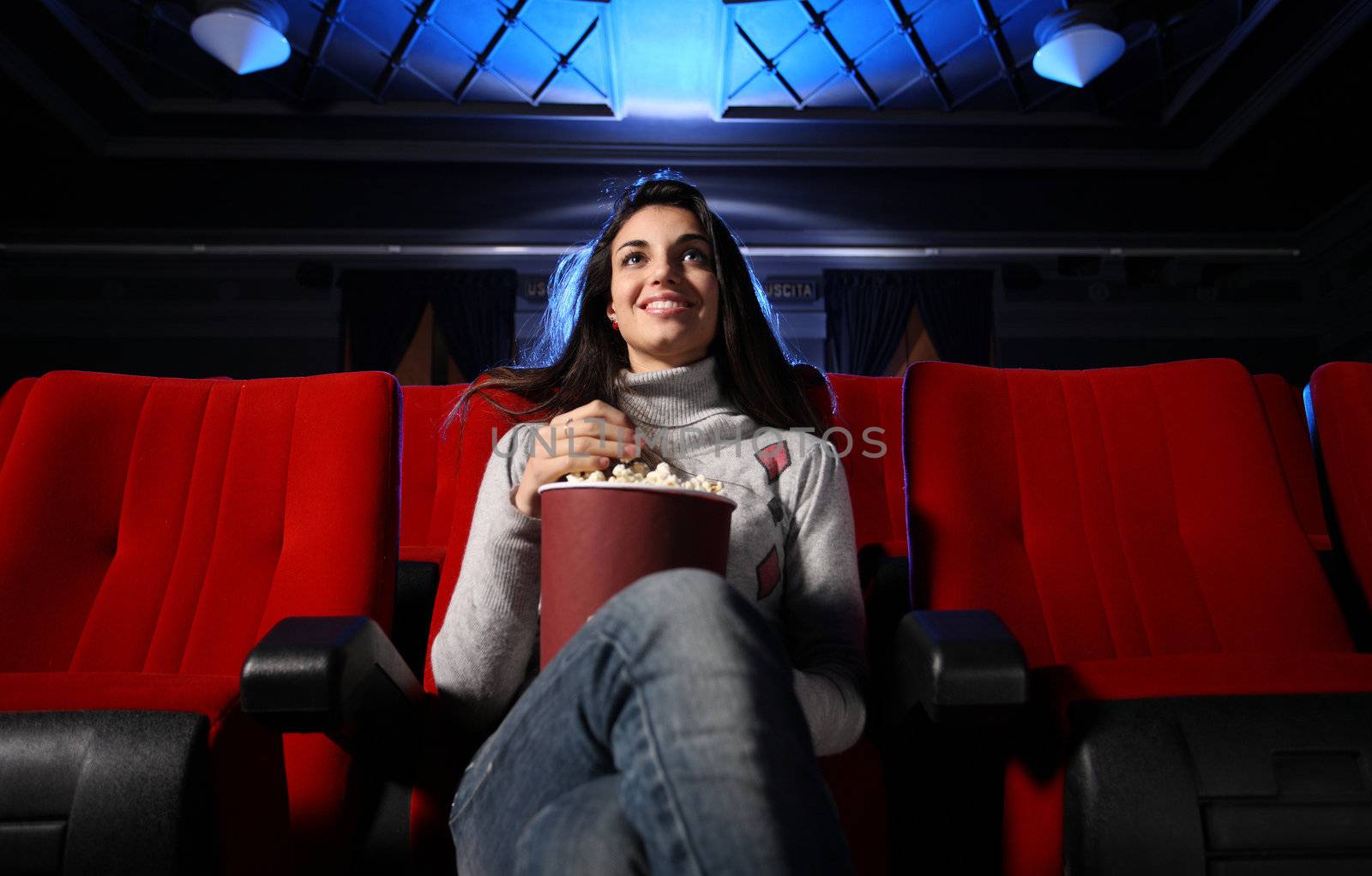 watching a movie at the cinema: portrait of a pretty girl in a m by stokkete