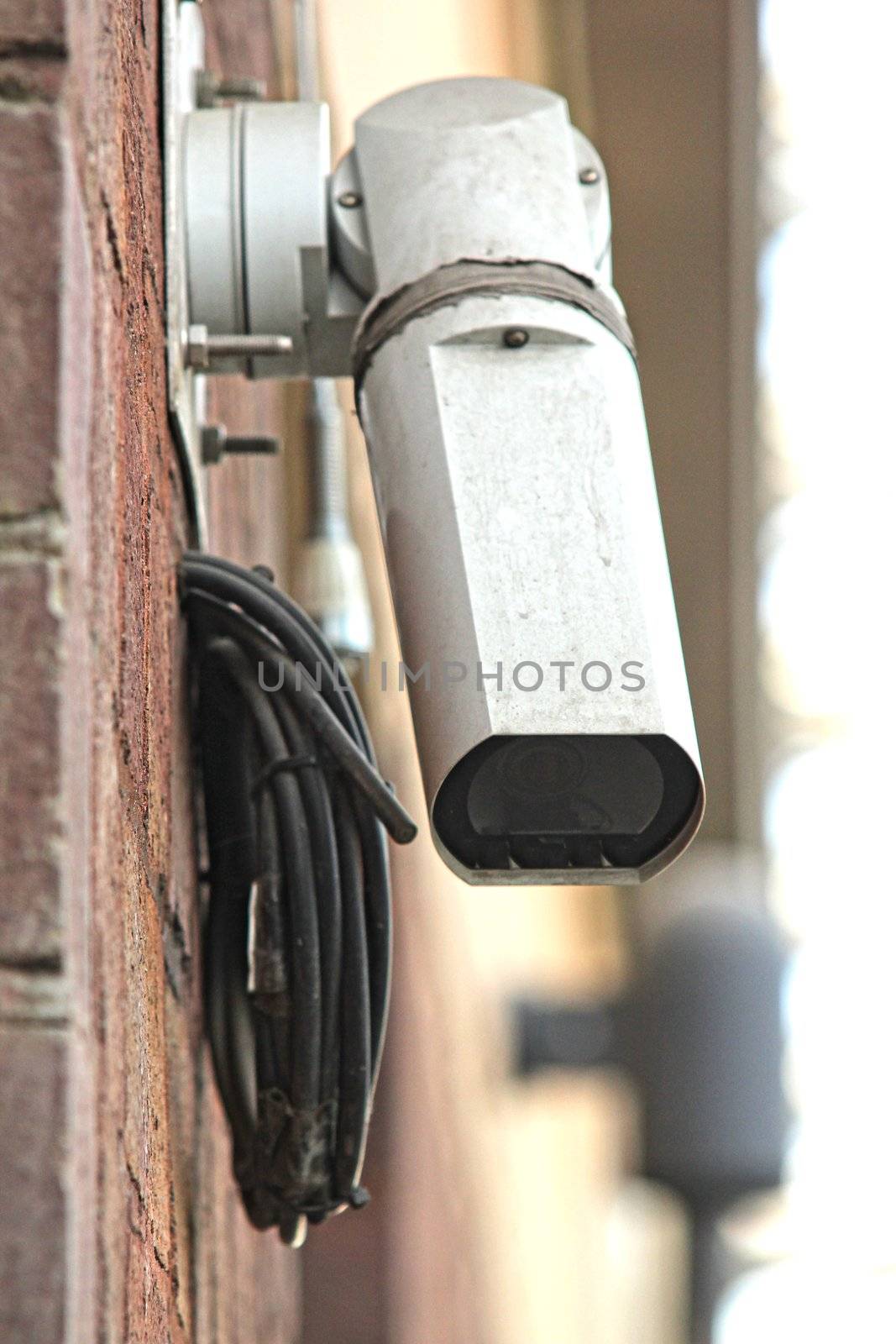 CCTV security camera on brick building watching the area by Arvebettum