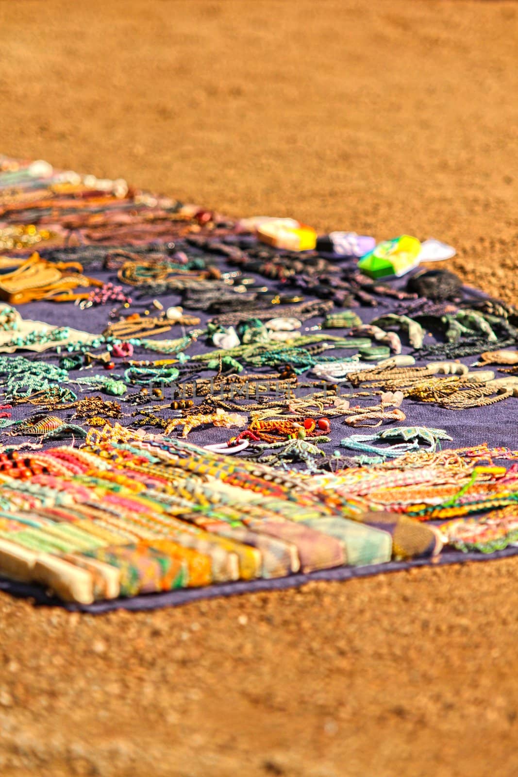 Assorted handmade jewelries on a carpet, at street market by Arvebettum