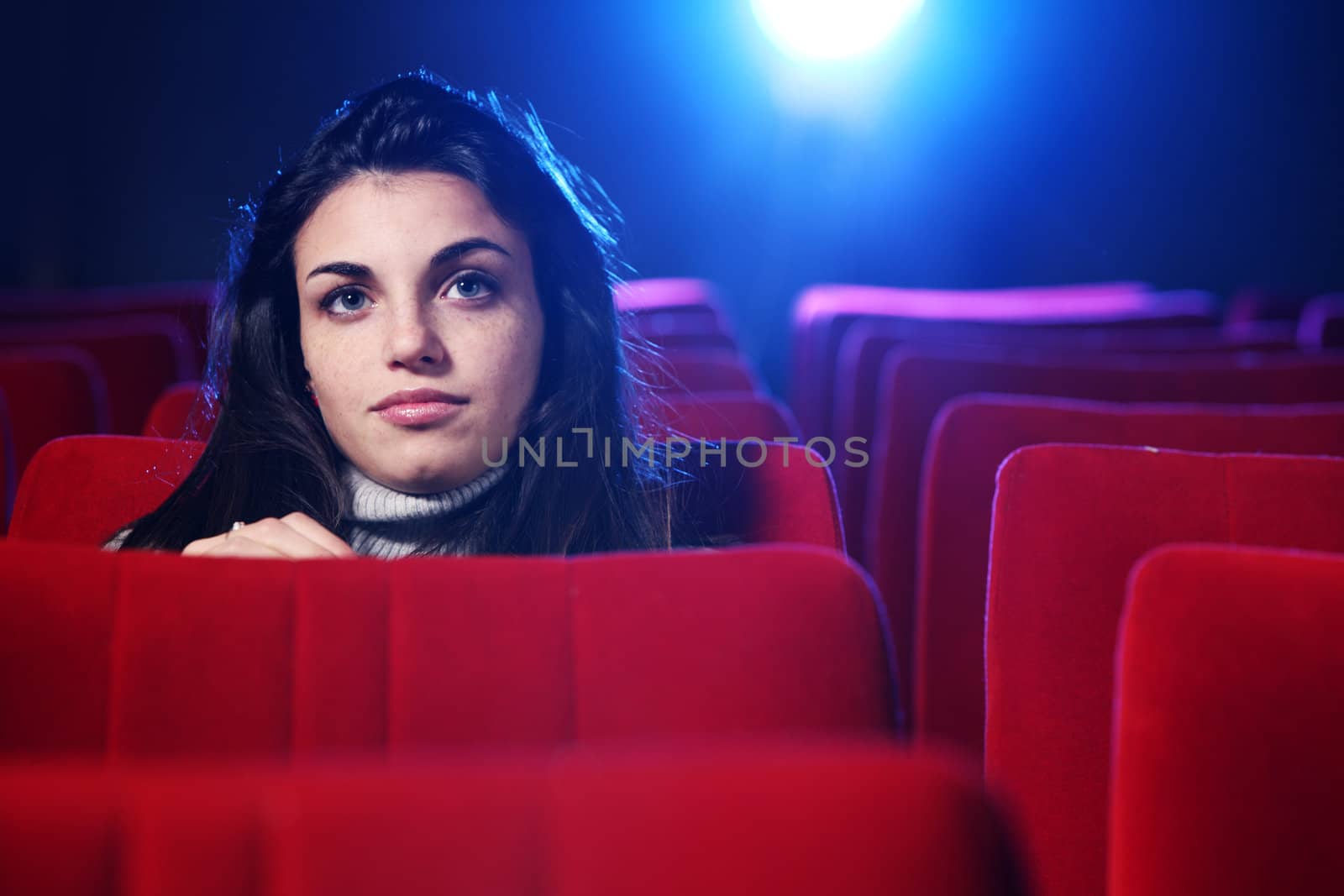 portrait of a pretty young woman at cinema by stokkete