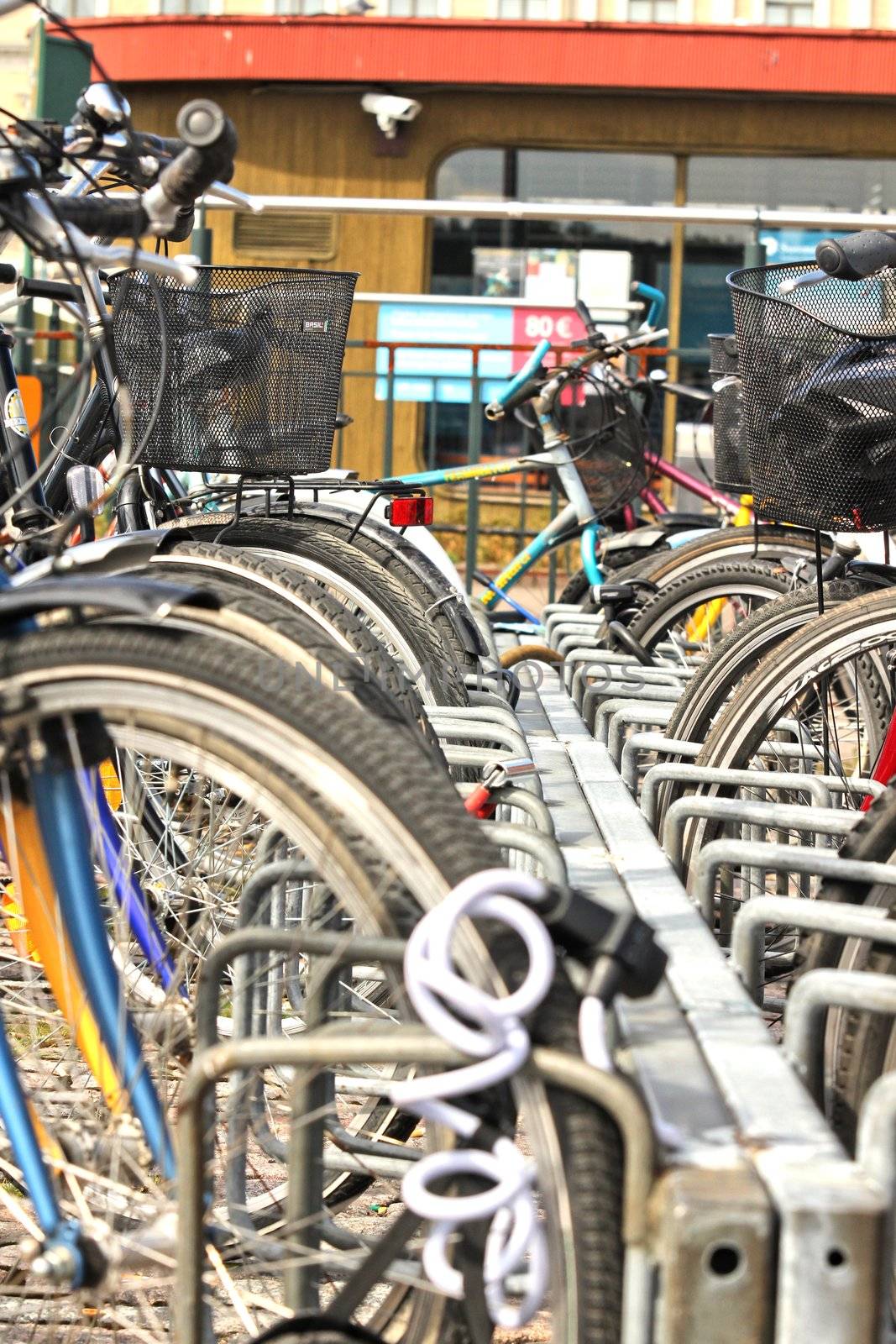 Bikes parked in the city, in a nice line into a rack by Arvebettum