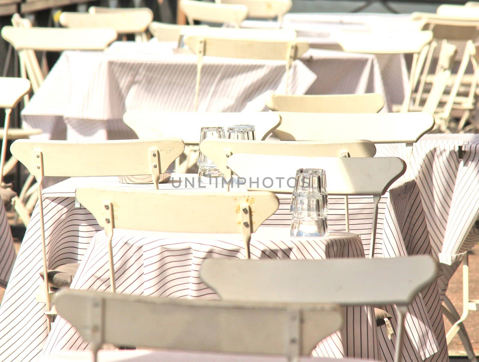 White chairs and tables, outdoors at a restaurant