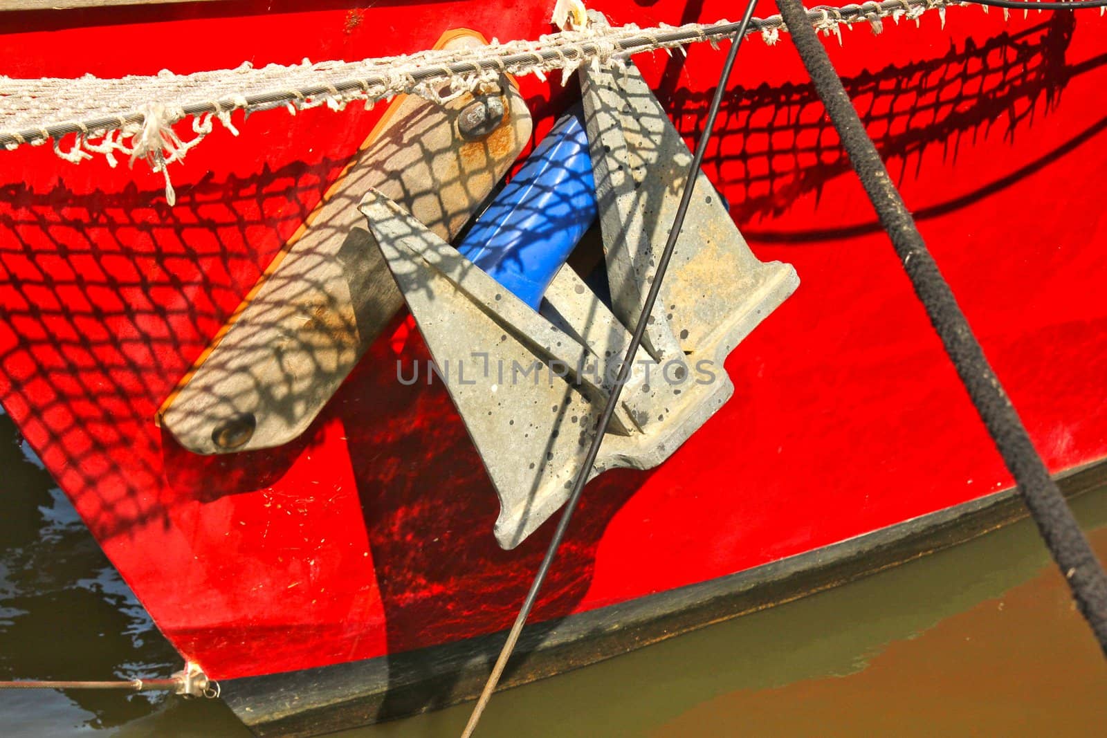 Closeup red bow and rusty anchor from a fishing boat