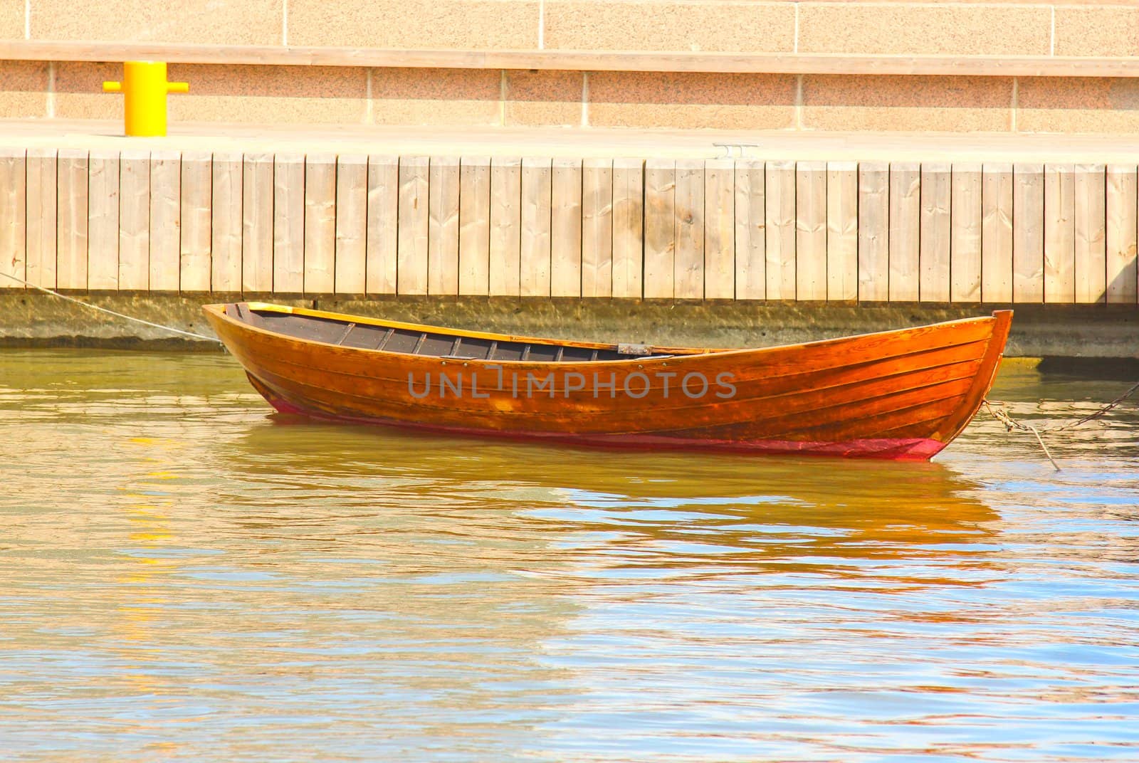 A wooden rowing boat tide down at harbor