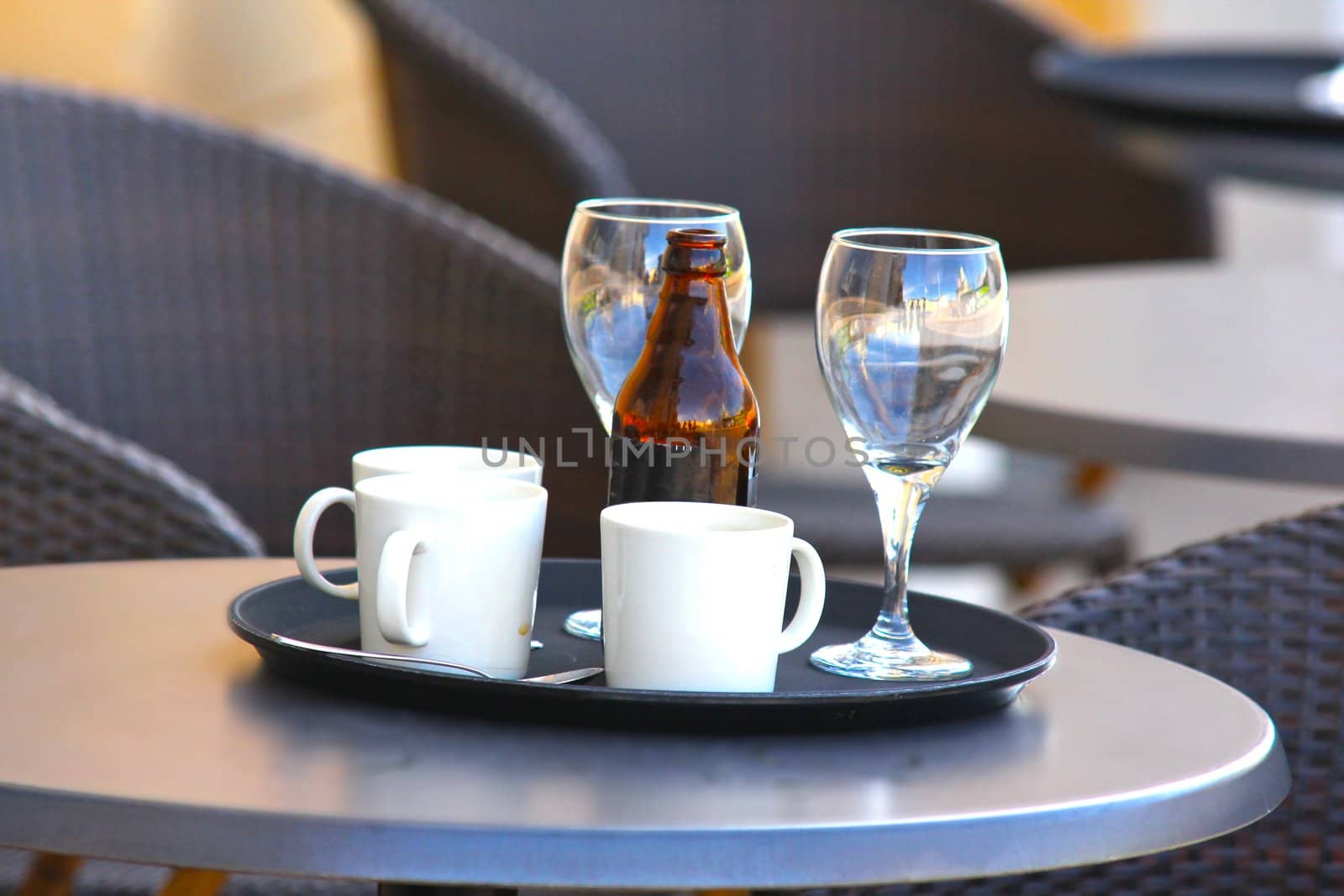 Restaurant outdoors, beer bottle on table, nobody around by Arvebettum