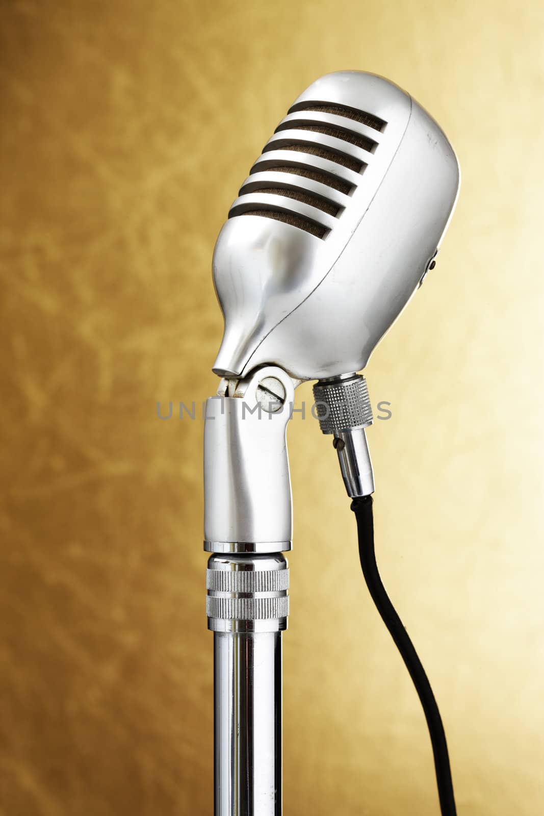 Retro style microphone. Gold background