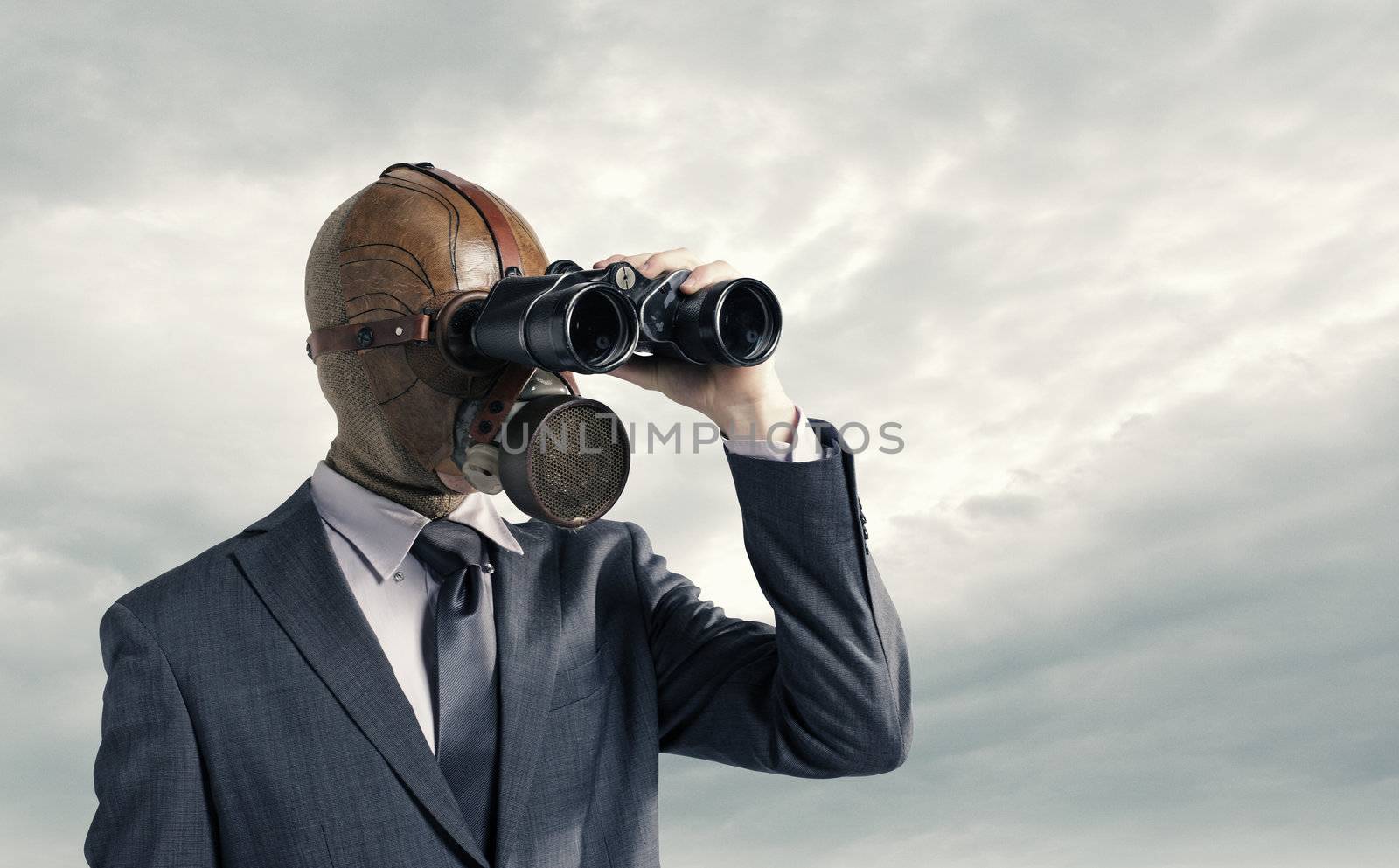 Businessman with gas mask  looking through binoculars by stokkete