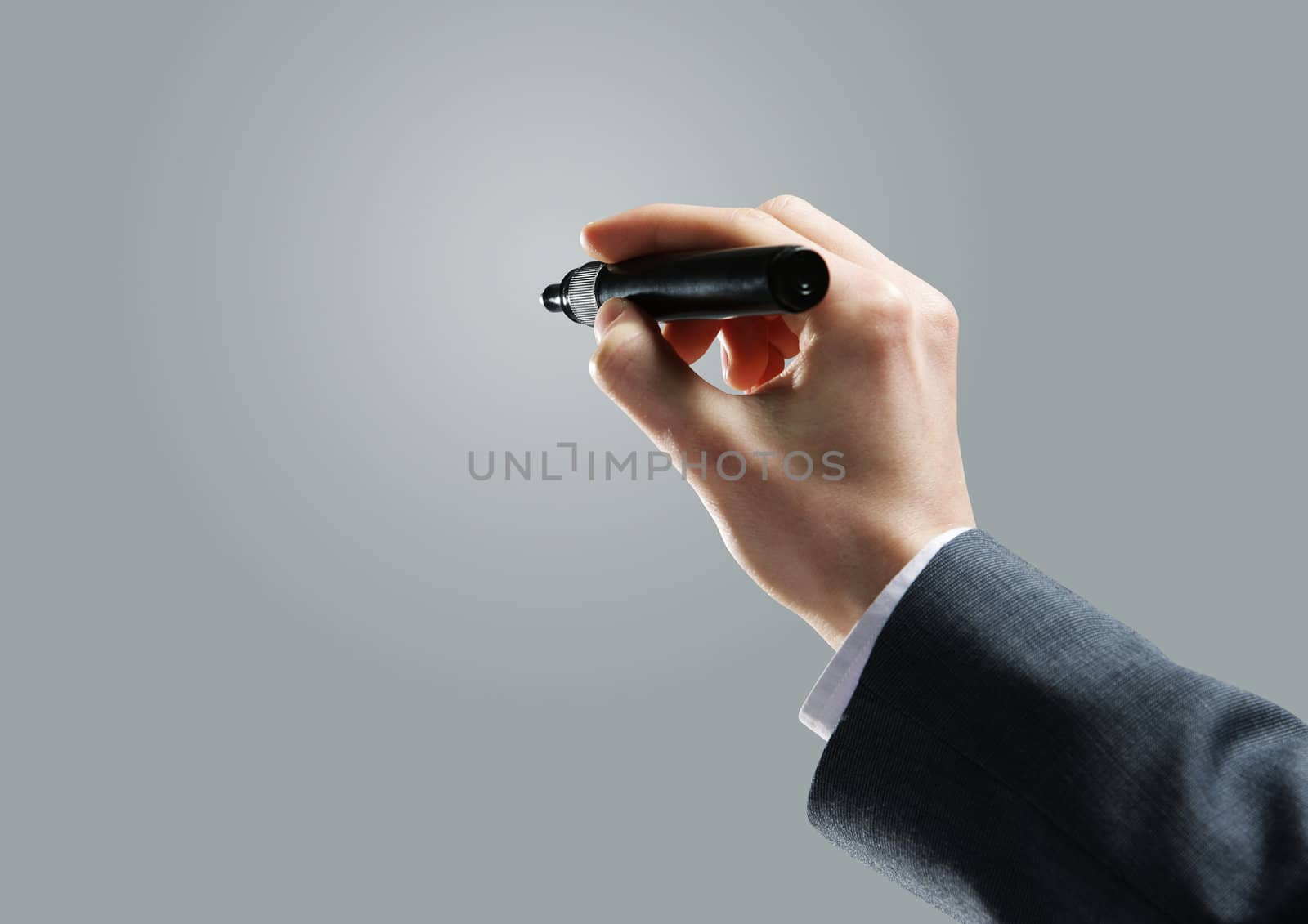 Businessman hand drawing in a blank whiteboard by stokkete