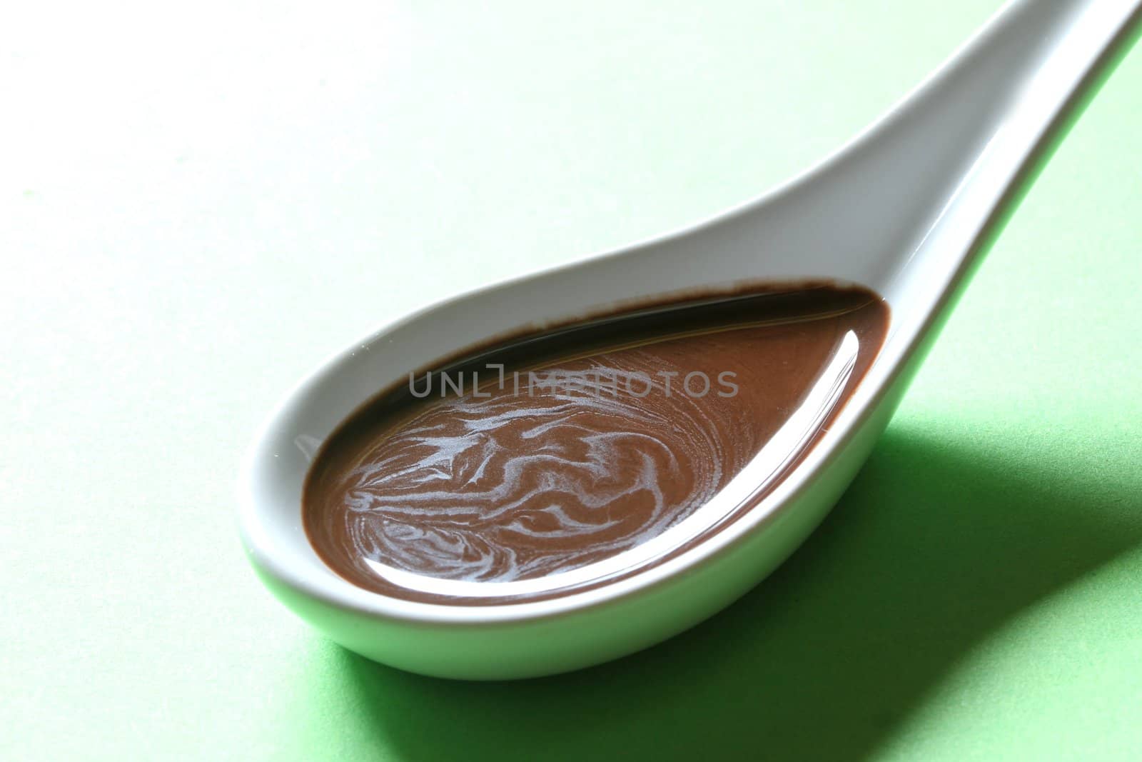 chocolate sauce on a porcelain spoon by Teka77