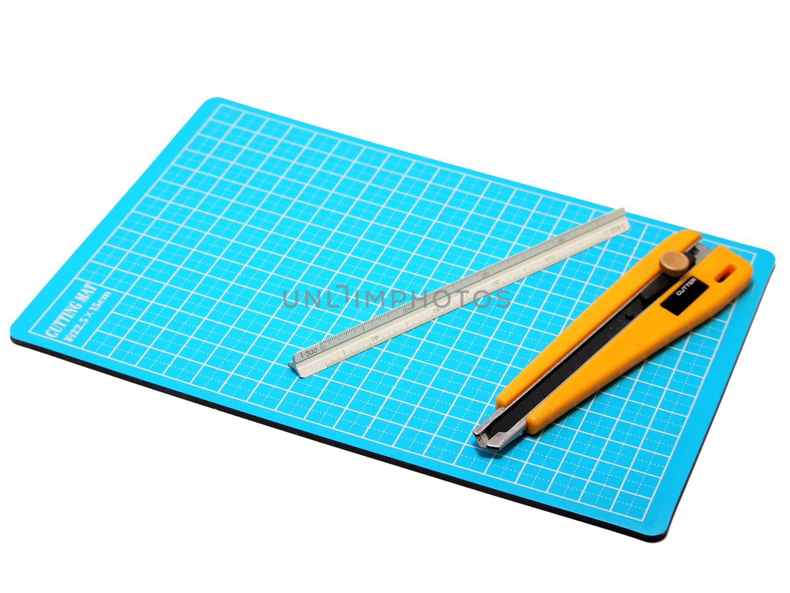 Cutter and Scale placed on blue cutting mat. by siraanamwong