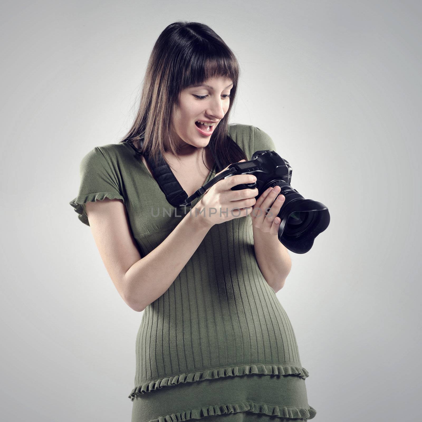 A young girl holds up a camera. by stokkete