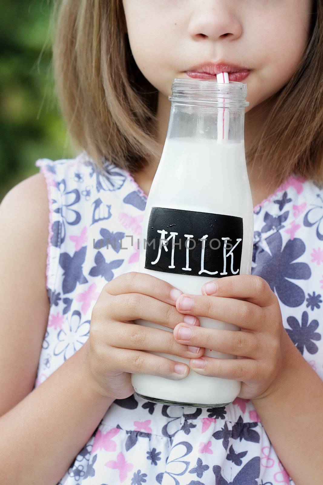 Little girl drinking a bottle of milk. Shallow depth of field with selective focus on milk.