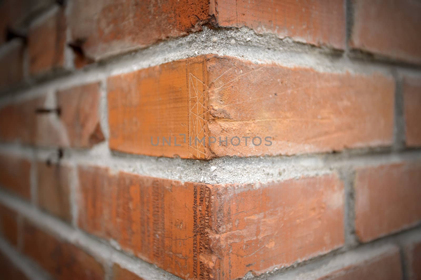 The corner of a red brick wall. Wide shot.