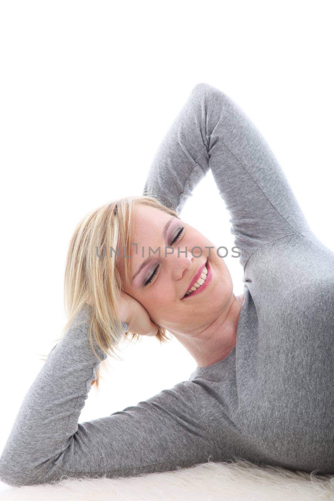 Satisfied blonde woman lying on white background