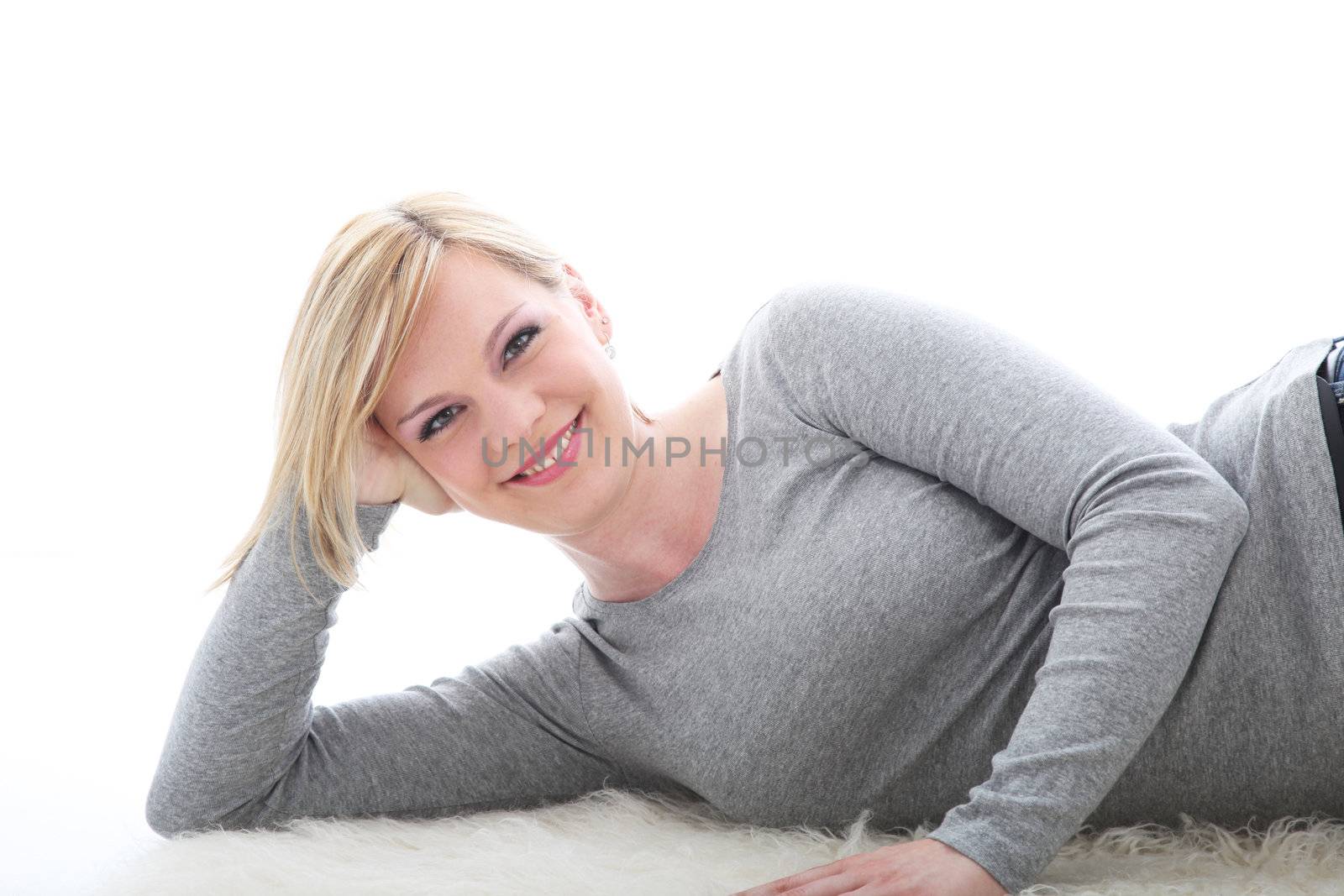 Relaxed smiling woman lying on white background
