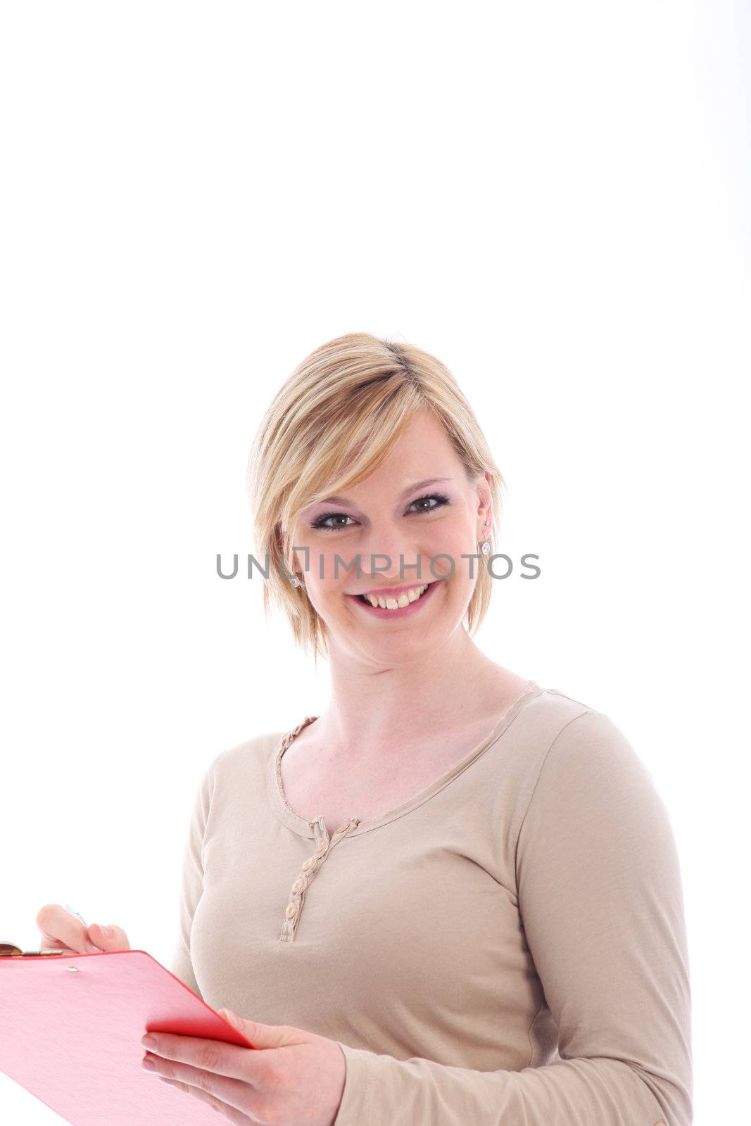 Pert attractive young lady with a lovely smile filling in a form which she is holding in her hand