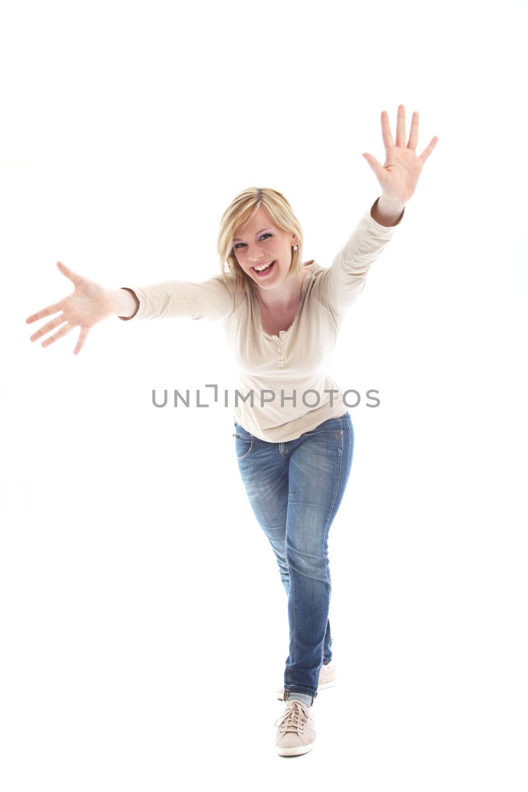 Beautiful vivacious blonde woman laughing as she leans forwards reaching towards the camera with both hands outstretched