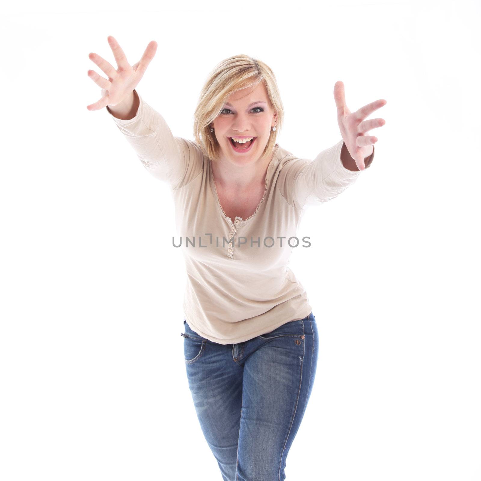 Happy vivacious young woman with a broad spotaneous smile holding her arms outsretched in welcome