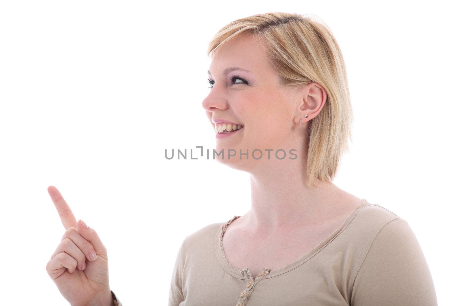 Smiling young blonde woman pointing upwads with her index finger to blank copyspace isolated on white