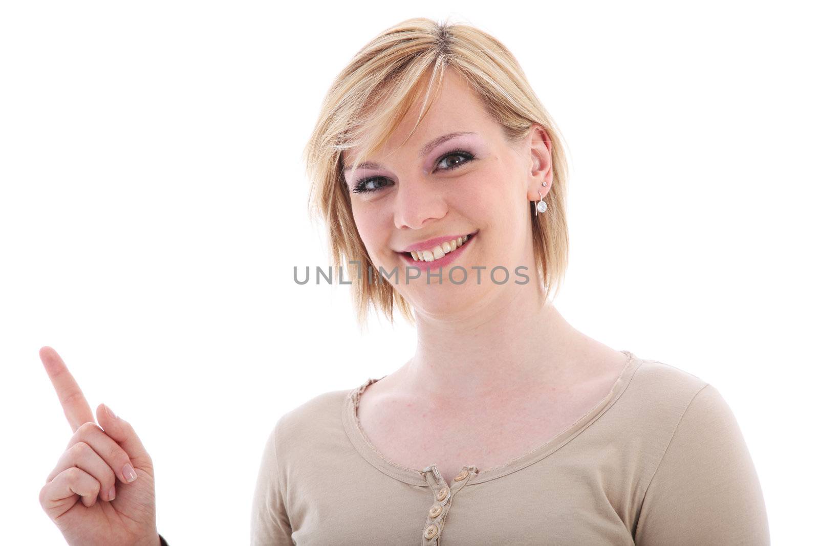 Attractive friendly smiling young saleslady pointing with her index finger to blank copyspace off frame at the left