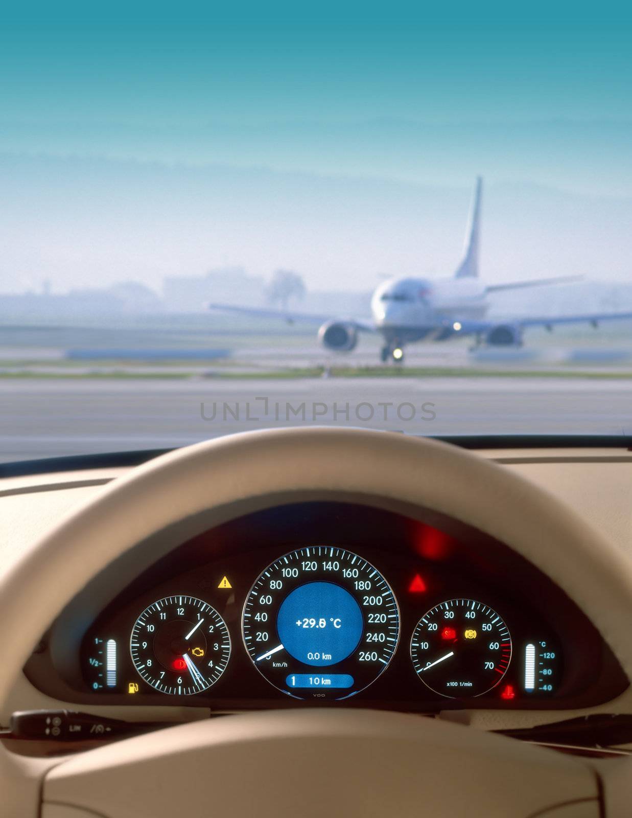 Wheel and dashboard of a car and view of airport