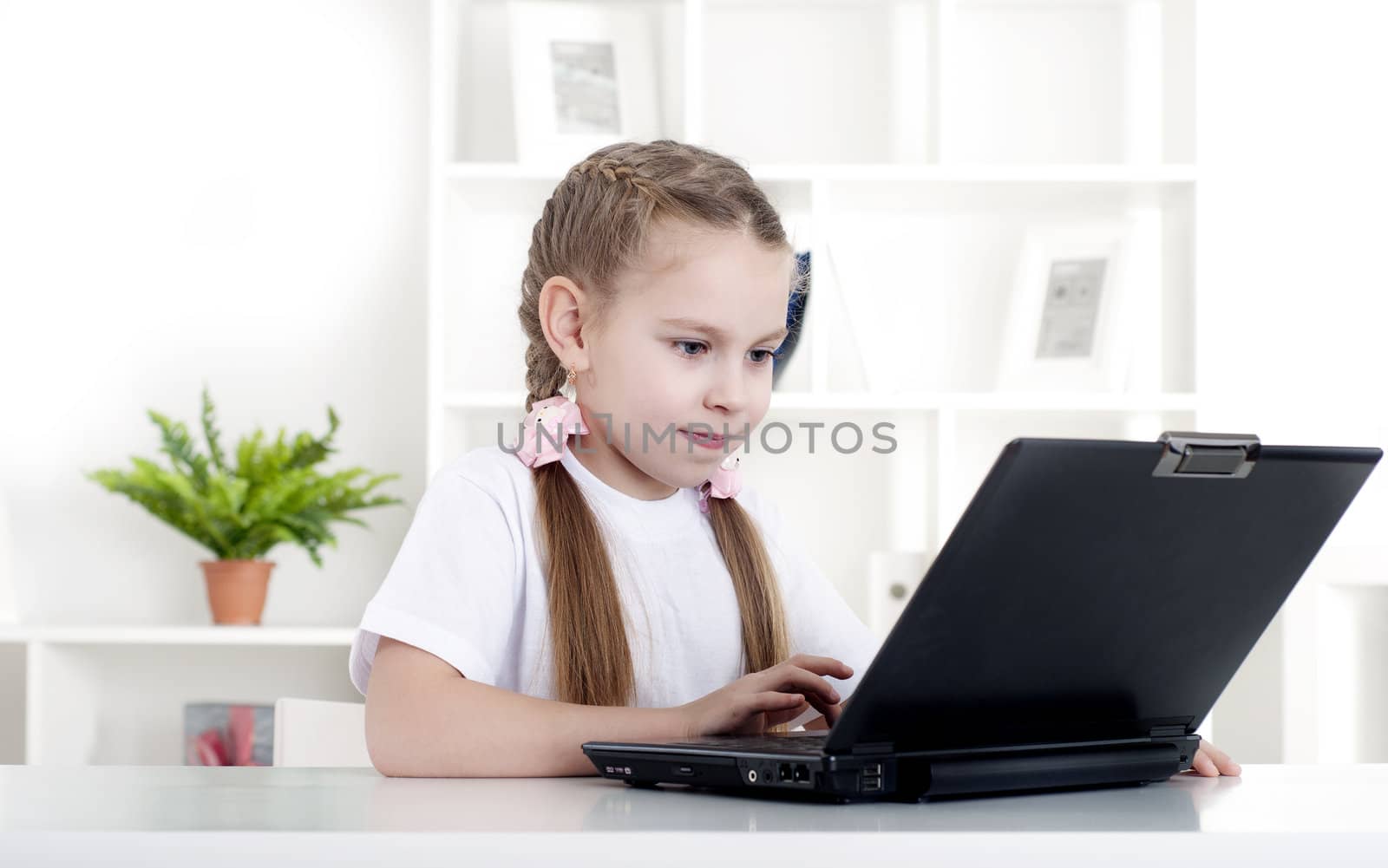 girl working on laptop at home, sitting at the table