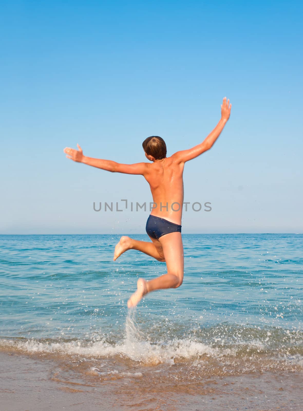 Boy jumping on beach. Concept for rest, relaxation, resorts.