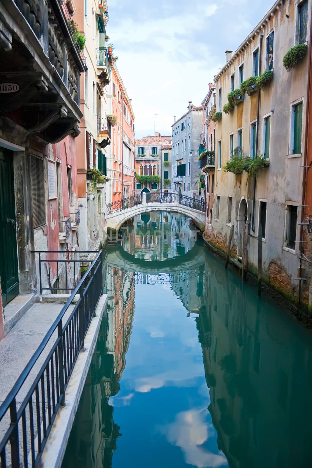 green and blue water of a typical venetian canal, Italy