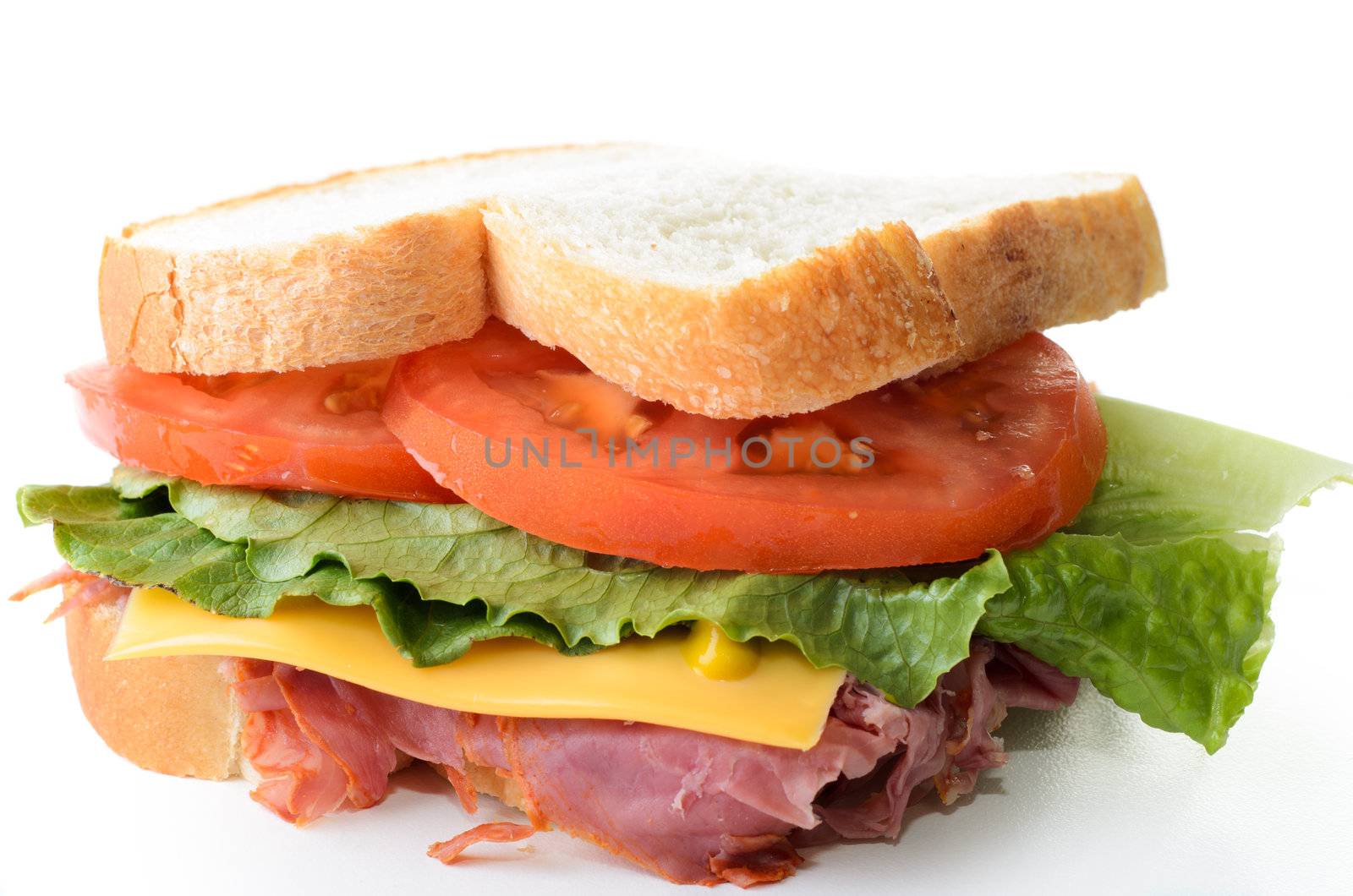 A corned beef sandwich with lettuce tomatoes and cheese.