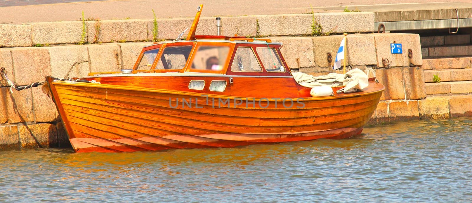 Shiny wooden boat, mooring in water at harbor by Arvebettum