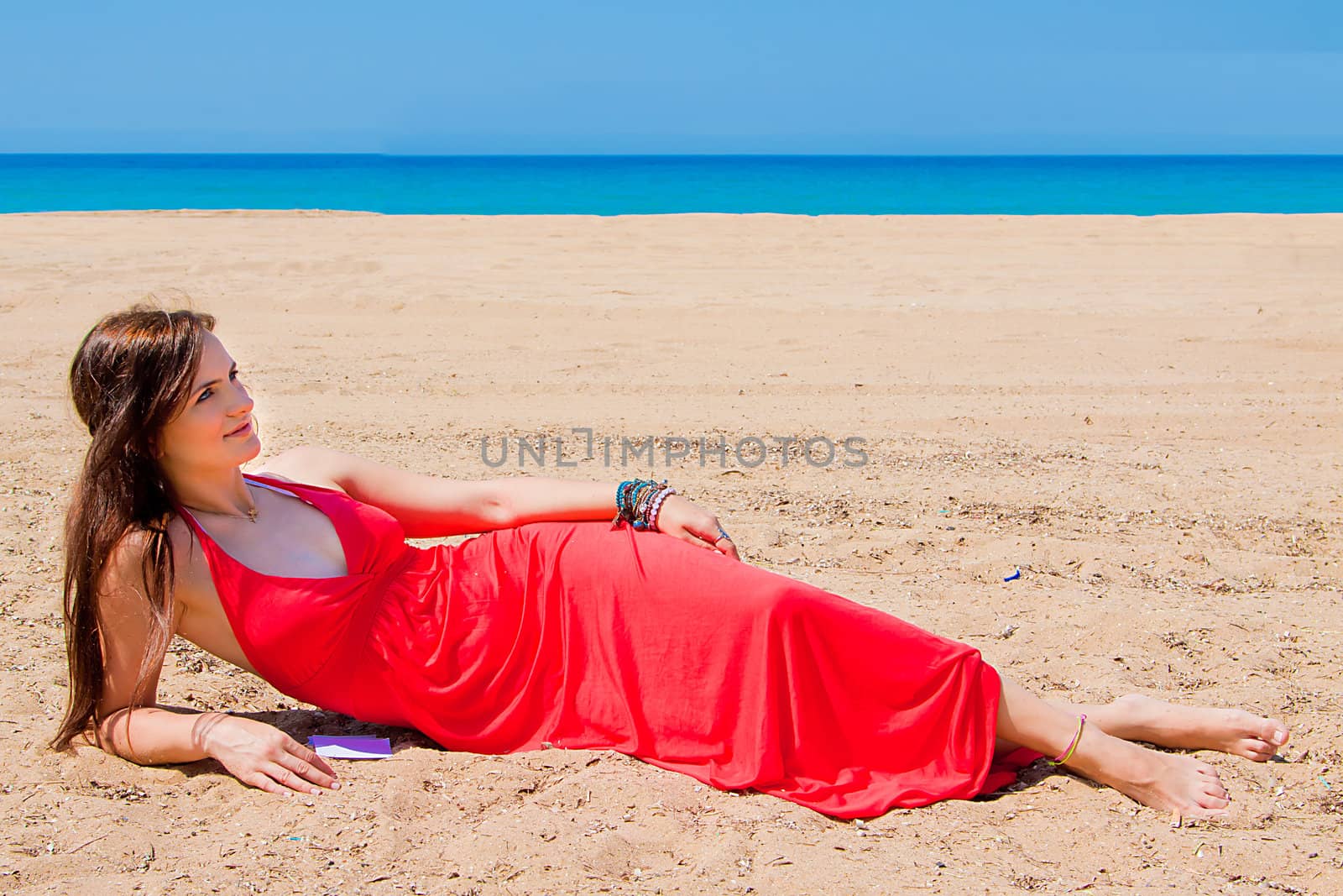 Photo of a young and beautiful woman resting on the sea coast