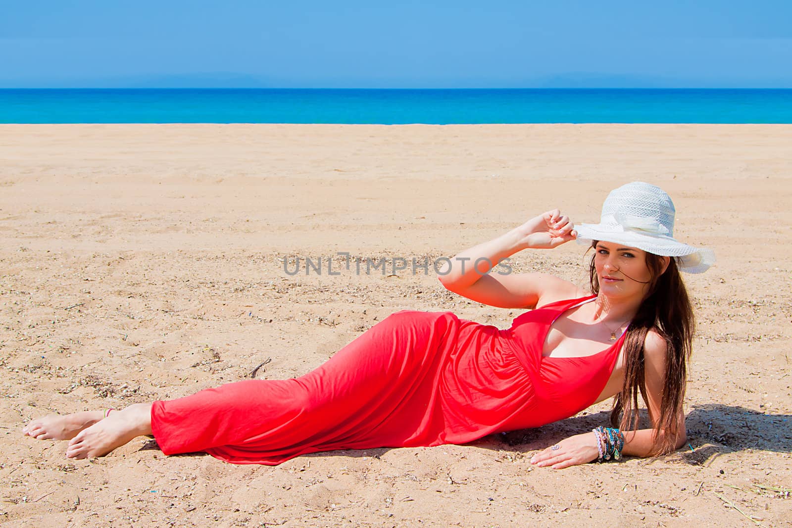 Photo of a young and beautiful woman resting on the sea coast