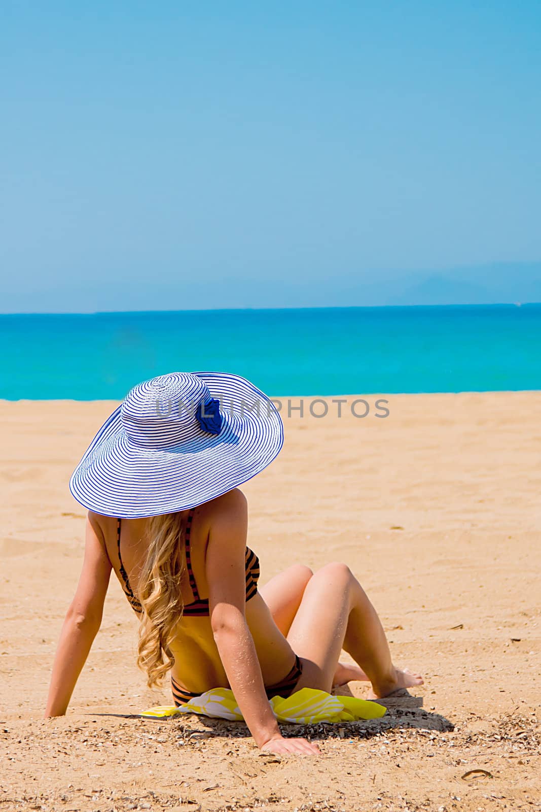 Photo of a young and beautiful woman resting on the sea coast