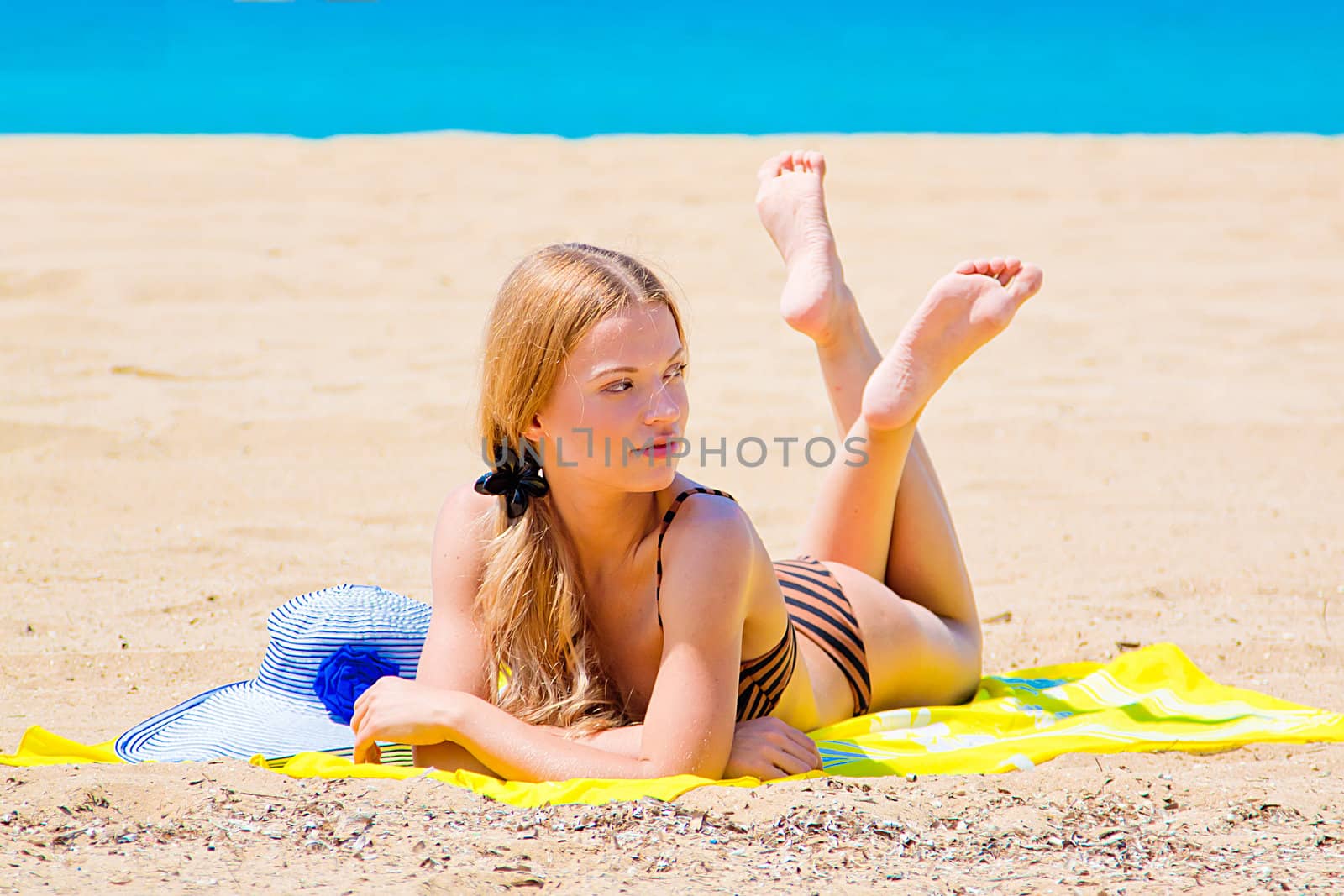 Photo of a young and beautiful woman resting on the sea coast