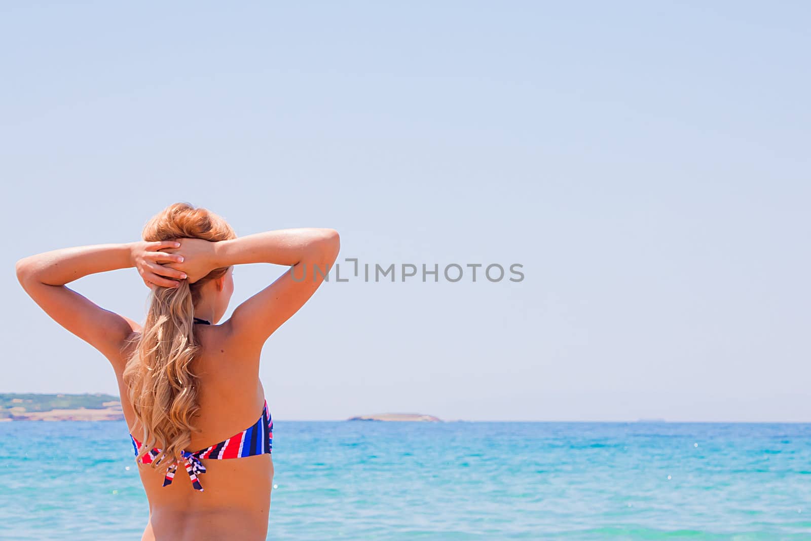 Photo of a young and beautiful woman resting on the sea coast