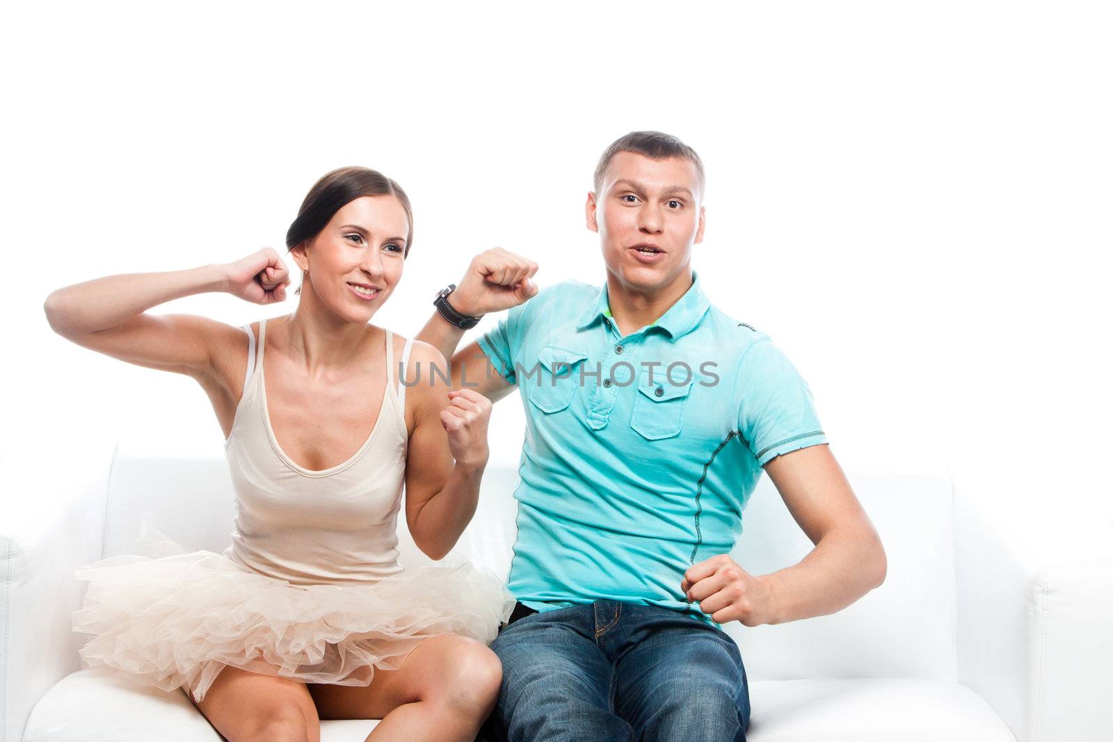 Group of sports fans watching the competition sitting on a white sofa