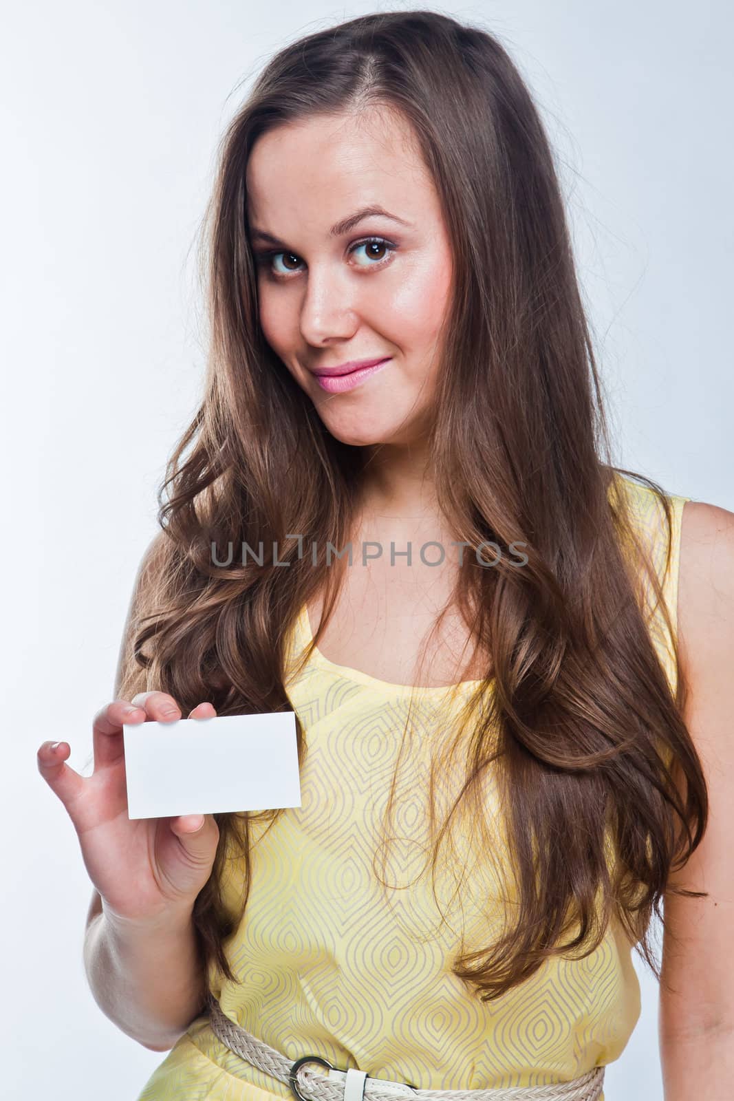 Photo of a young and beautiful woman with a business card in the hands of