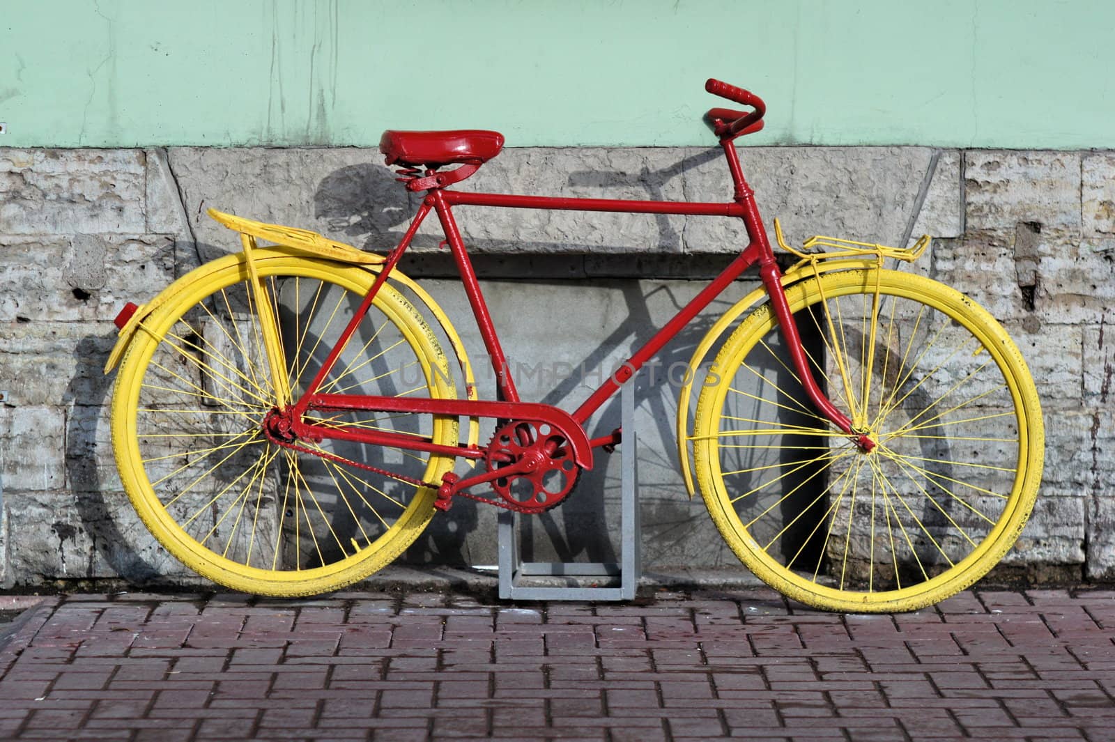 old yellow bicycle stands at the walls the city houses