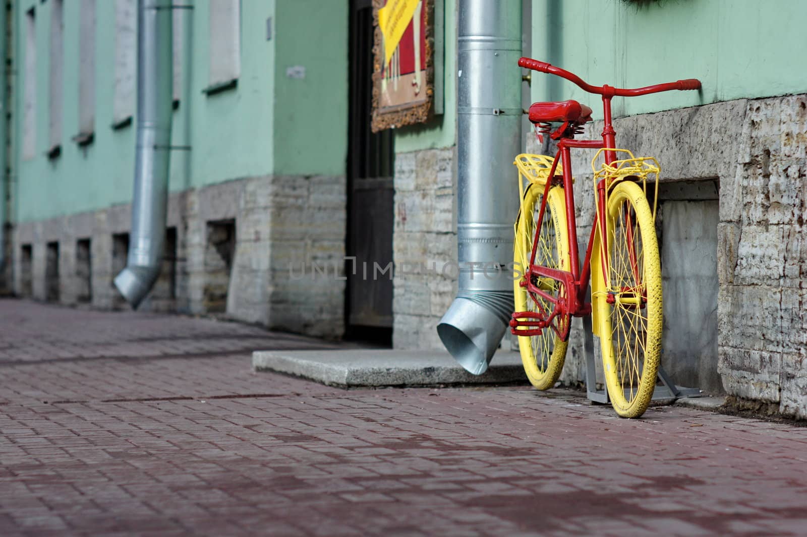 old yellow bicycle stands at the walls the city houses