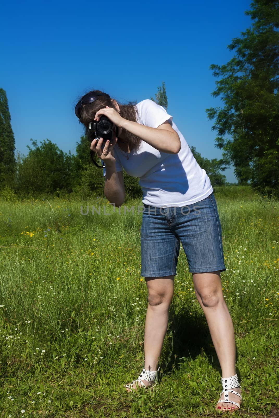 Young women is shoot landscape against a meadow and sky
