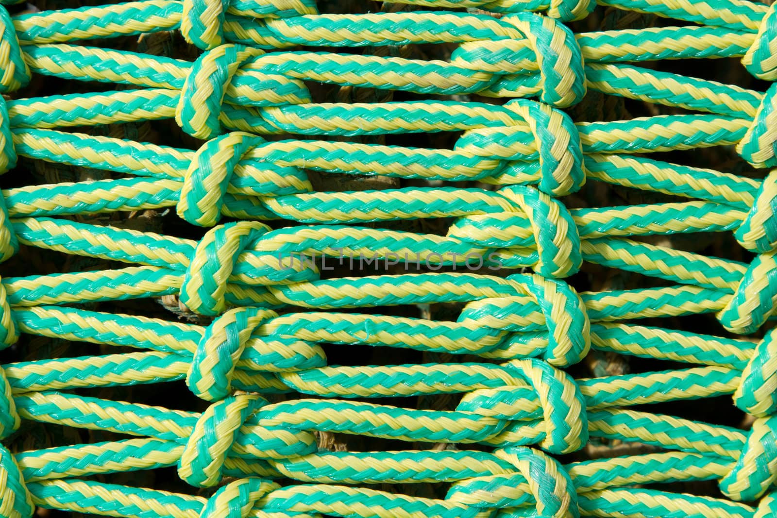 A linked, lined, knotted pattern made from green and yellow rope