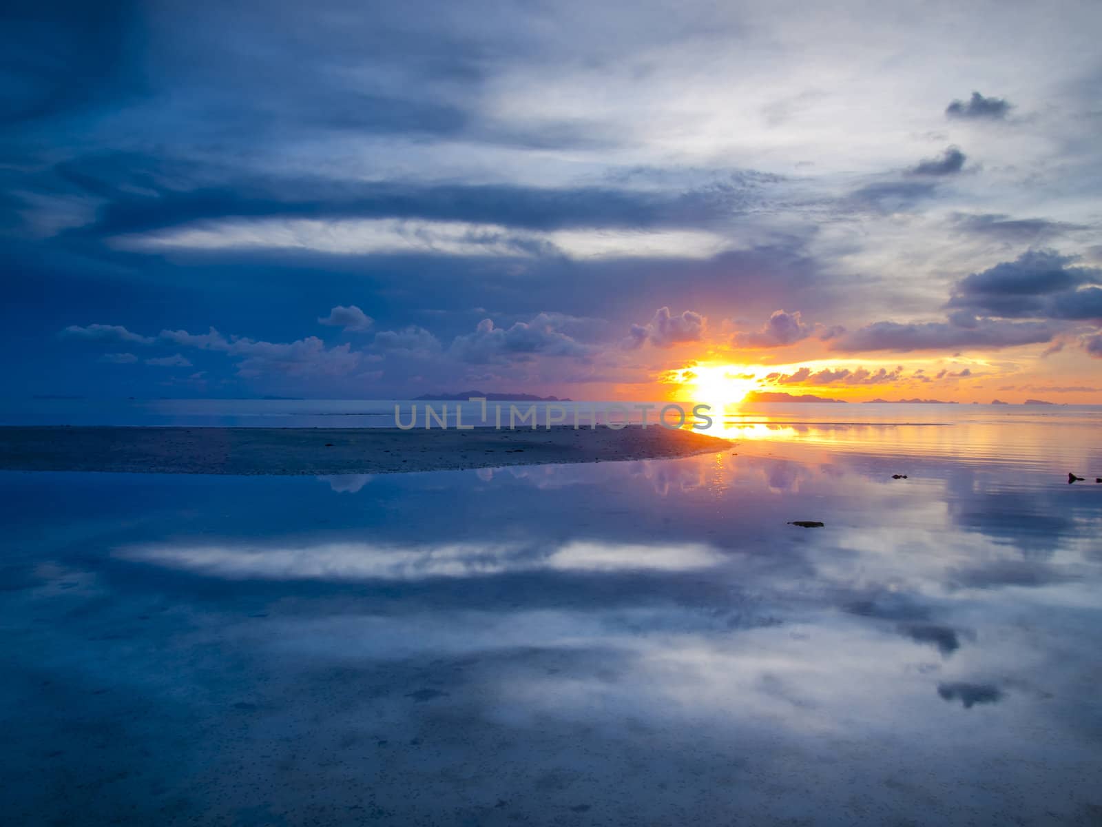 The sun sets over beach with beautiful reflection by jakgree