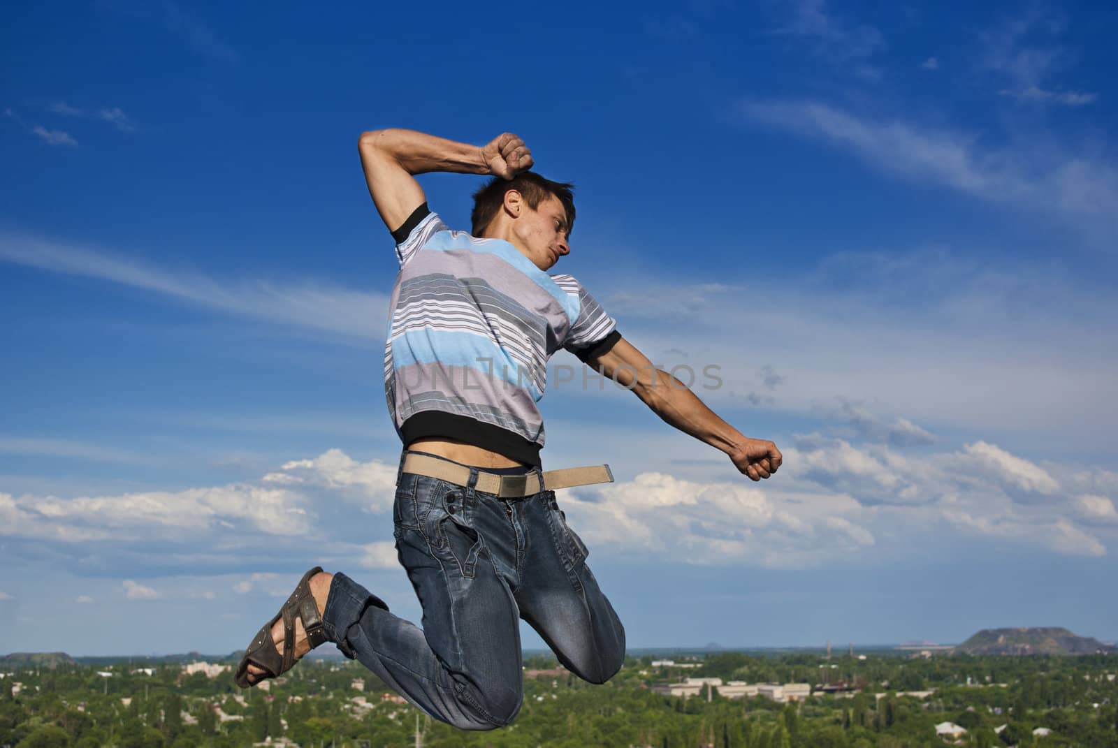 Boy jumping against a background of city and sky