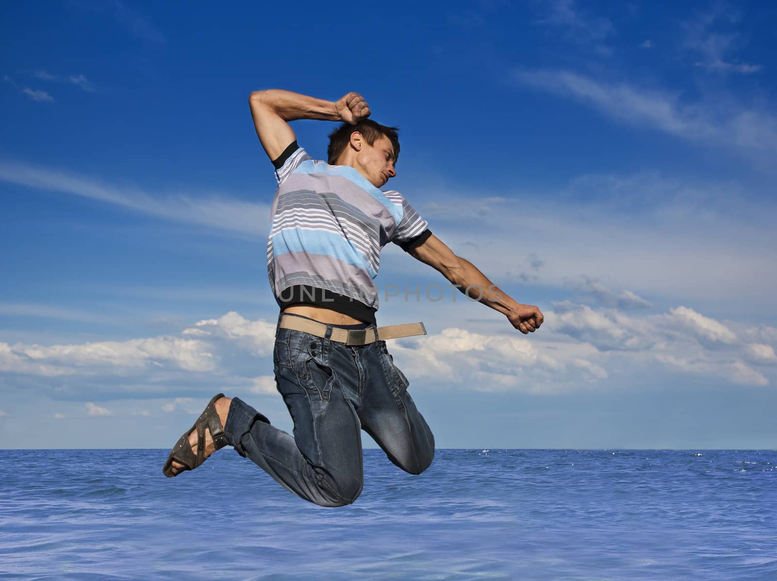 Boy jumping against a background of beautiful sky