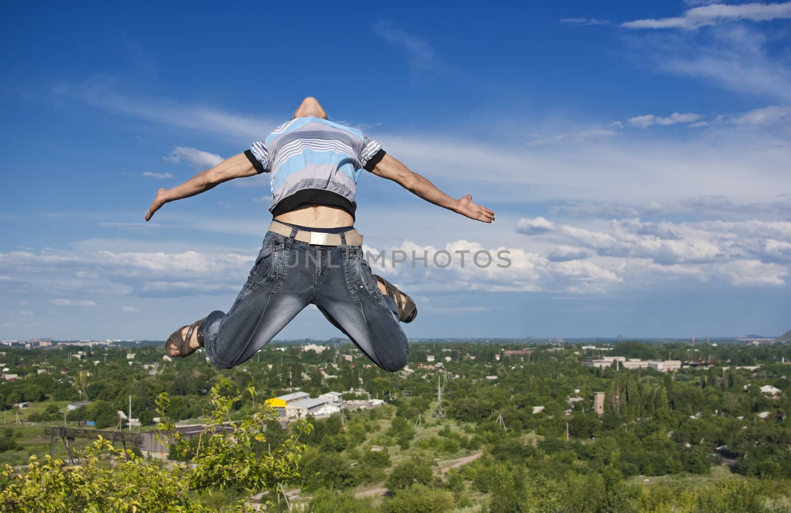 Boy jumping against a background of city and sky